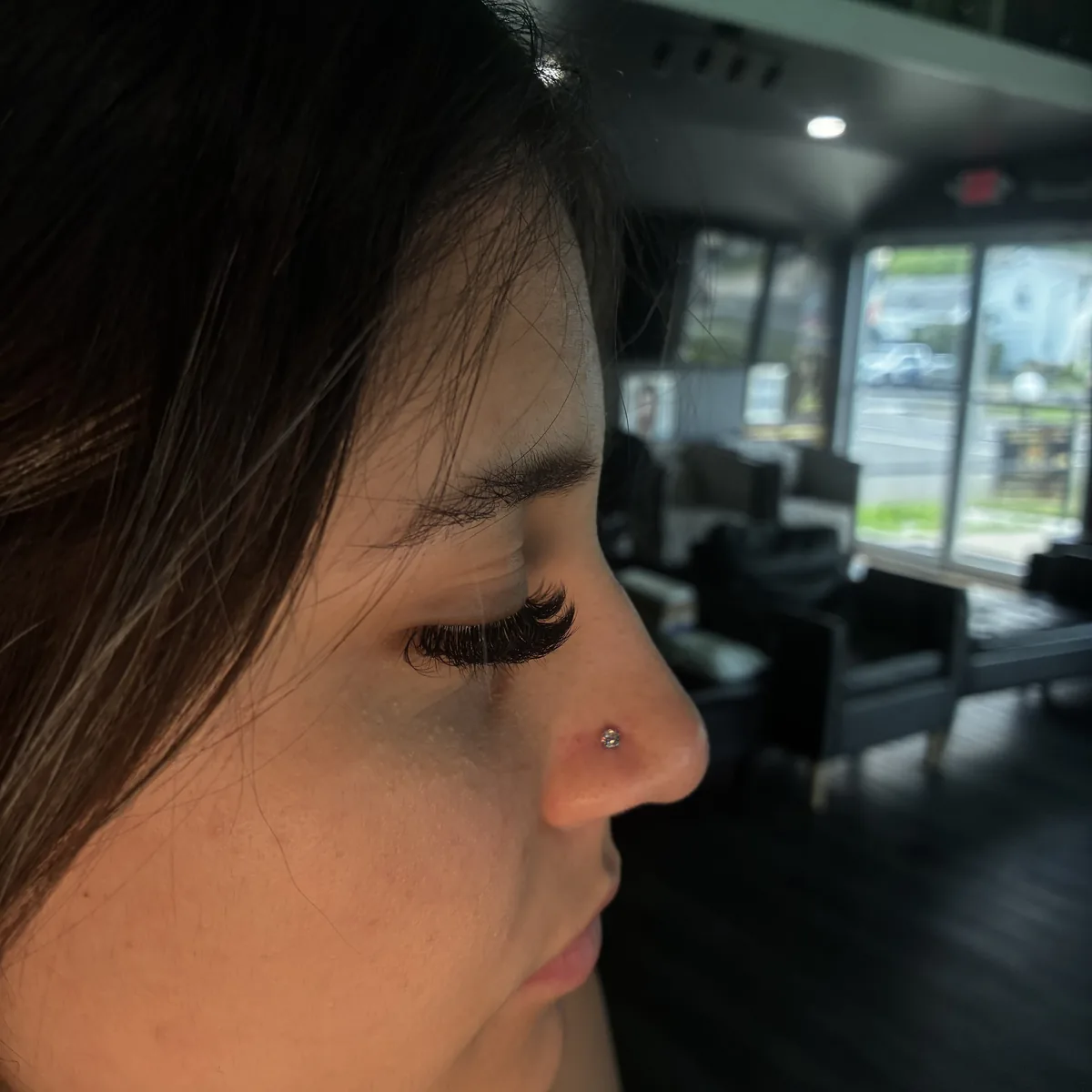 Nose piercing with a stud, shot inside the shop